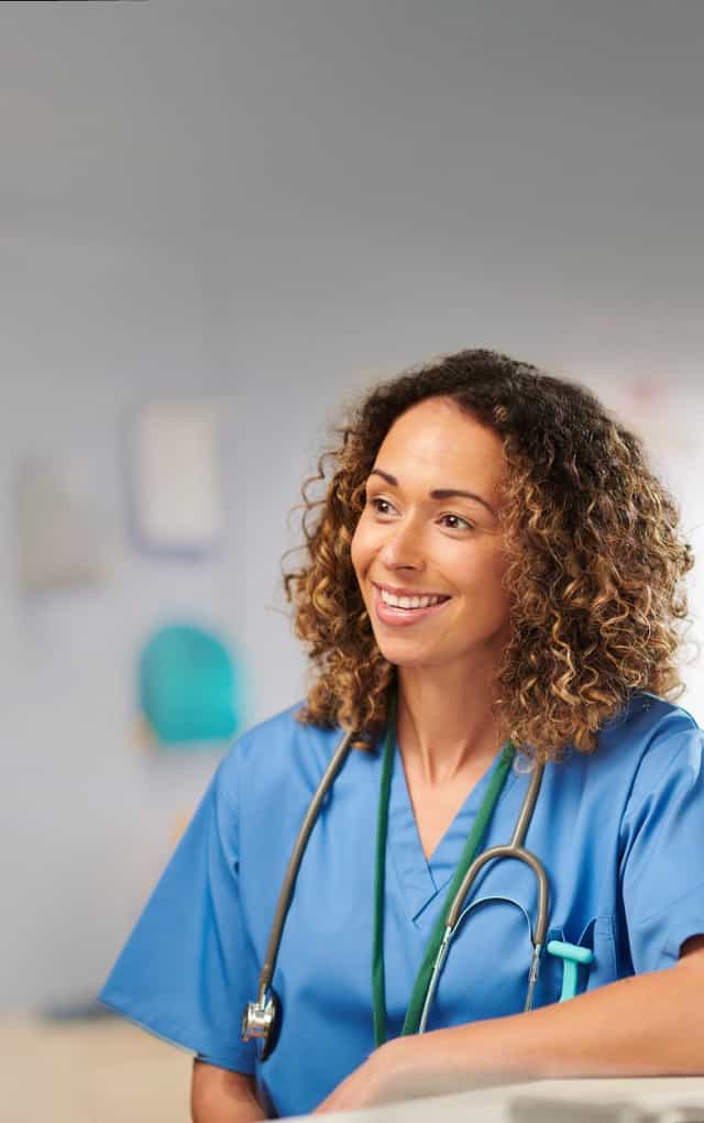 A female nurse helps an elderly patient up stairs in a home.