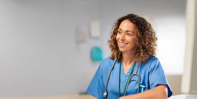 A female nurse helps an elderly patient up stairs in a home.