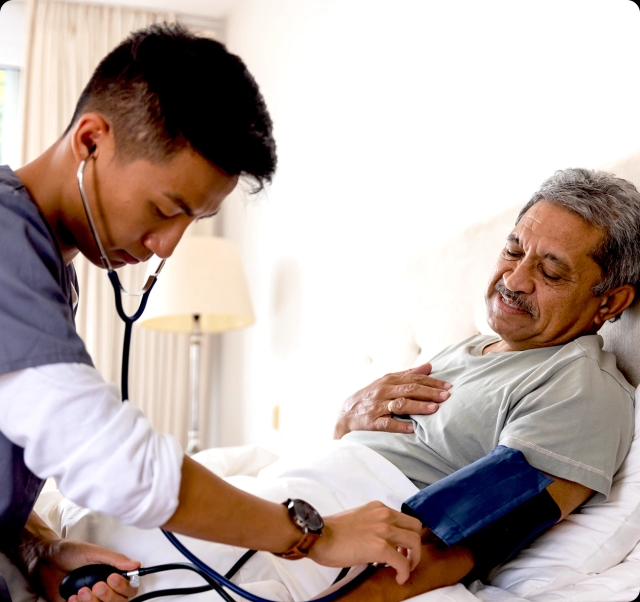 A healthcare worker examines an elderly man.